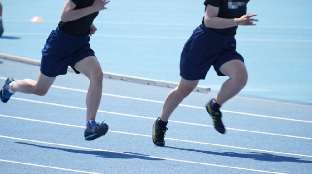陸上トラックで練習する中学生